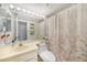 Standard toilet and sink with floral patterned shower curtain at 1501 Beach Rd # 310, Englewood, FL 34223