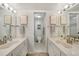 Bright bathroom features dual sinks, large mirrors, and separate toilet and shower area at 1501 Beach Rd # 310, Englewood, FL 34223