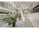 View of hallway with courtyard featuring many potted plants and white stones at 1501 Beach Rd # 310, Englewood, FL 34223
