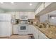 Updated kitchen featuring granite counters, modern appliances, and tiled backsplash at 1501 Beach Rd # 310, Englewood, FL 34223