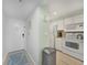 Galley kitchen with white appliances, light countertops, and a stainless steel trash receptacle at 1501 Beach Rd # 310, Englewood, FL 34223