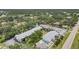 Aerial view featuring condos in a lush, green area near a pond and the community pool at 1730 Manasota Beach Rd # 204, Englewood, FL 34223