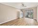 Bedroom with neutral color scheme, ceiling fan, modern floors, and sliding glass door to balcony at 1730 Manasota Beach Rd # 204, Englewood, FL 34223