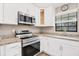 Bright kitchen featuring stainless steel appliances, granite countertops, and white cabinetry at 1730 Manasota Beach Rd # 204, Englewood, FL 34223
