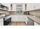 Updated kitchen featuring white cabinets, stainless steel appliances, and granite countertops at 1730 Manasota Beach Rd # 204, Englewood, FL 34223