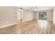 Large living room with modern flooring, neutral walls, ceiling fan, and sliding door to the balcony at 1730 Manasota Beach Rd # 204, Englewood, FL 34223
