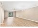 Spacious living room with modern flooring, neutral paint, ceiling fan, and sliding doors to balcony at 1730 Manasota Beach Rd # 204, Englewood, FL 34223