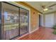 Covered patio features red tile floor, ceiling fan, and sliding glass doors to the interior at 1730 Manasota Beach Rd # 204, Englewood, FL 34223