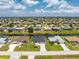Wide aerial view of a neighborhood with many homes, canals, and well-maintained landscaping at 209 Fairway Rd, Rotonda West, FL 33947