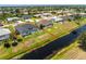 Aerial view of a home's backyard featuring a screened-in pool area and canal-front property at 209 Fairway Rd, Rotonda West, FL 33947