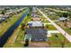 Aerial view of a home with a pool, fenced yard, and canal frontage within a residential neighborhood at 209 Fairway Rd, Rotonda West, FL 33947