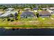 Aerial view of a home with a screened pool and backyard with lake views and a well-maintained lawn at 209 Fairway Rd, Rotonda West, FL 33947