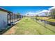 A fenced backyard with a canal view, complemented by a screened enclosure offering an outdoor living space at 209 Fairway Rd, Rotonda West, FL 33947