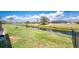 A backyard with a well-maintained lawn, black chain link fence, and access to a canal with lush green banks at 209 Fairway Rd, Rotonda West, FL 33947