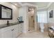 Bathroom featuring tiled walls, granite countertops, glass shower, and natural light at 209 Fairway Rd, Rotonda West, FL 33947