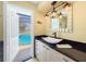 Chic bathroom featuring vessel sink, modern fixtures and an open doorway to the serene pool area at 209 Fairway Rd, Rotonda West, FL 33947