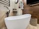 Luxurious bathroom featuring a large soaking tub, wall-mounted TV, and rustic wood accents at 209 Fairway Rd, Rotonda West, FL 33947