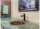 Bathroom sink with copper basin and green stone countertop, set against tiled walls at 209 Fairway Rd, Rotonda West, FL 33947