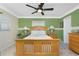 Bright bedroom with soft natural light, complemented by a light wood bed frame and a ceiling fan for comfort at 209 Fairway Rd, Rotonda West, FL 33947