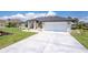 Home exterior featuring a front entrance, attached garage, and a well-maintained driveway with mature landscaping at 209 Fairway Rd, Rotonda West, FL 33947