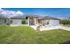 Charming single-story home with a well-manicured lawn and decorative front entrance with an attached garage at 209 Fairway Rd, Rotonda West, FL 33947