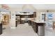 Spacious kitchen with dark wood cabinets, stainless steel appliances, and an open layout to the dining area at 209 Fairway Rd, Rotonda West, FL 33947