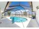 Inviting screened in pool area with a beautiful blue pool, white concrete flooring and metal enclosure at 209 Fairway Rd, Rotonda West, FL 33947