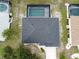 Drone's-eye view of a home showing the roof, driveway, and an inviting screened-in pool area at 21 Sportsman Way, Rotonda West, FL 33947