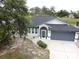 Beautifully landscaped home showcasing the driveway, front entrance, and a lush, green lawn at 21 Sportsman Way, Rotonda West, FL 33947