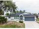 Charming home with a well-manicured lawn, gray garage door, and an inviting front entrance at 21 Sportsman Way, Rotonda West, FL 33947