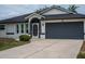 Close-up of home's exterior featuring a large two-car garage and welcoming front entryway at 21 Sportsman Way, Rotonda West, FL 33947