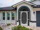 A beautifully decorated front door with an arched entryway and white rock landscaping at 21 Sportsman Way, Rotonda West, FL 33947