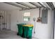 Well-organized garage with trash bins, electrical panel, and an exit door enhances the home's utility and accessibility at 21 Sportsman Way, Rotonda West, FL 33947