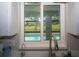 Kitchen sink under a large window with view of a swimming pool and green backyard at 21 Sportsman Way, Rotonda West, FL 33947