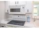 Bright kitchen featuring sleek white appliances including a microwave, range, and stainless steel faucet at 21 Sportsman Way, Rotonda West, FL 33947
