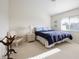 Cozy bedroom featuring a blue-covered bed, white wicker chair, and neutral colored walls and carpet at 2295 Chilcote Ter, Port Charlotte, FL 33981