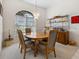 Dining room with wood table, cushioned chairs, decorative lighting fixture, shelving and bright arched window at 2295 Chilcote Ter, Port Charlotte, FL 33981
