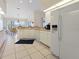 Bright kitchen features white cabinets, appliances, and tile flooring with an adjacent breakfast nook at 2295 Chilcote Ter, Port Charlotte, FL 33981
