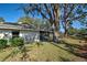 A cozy backyard featuring lush green grass, mature trees, and a glimpse of the tranquil lake at 232 Southampton Ln # 259, Venice, FL 34293
