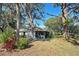 Back exterior view with mature trees and view into screened in porch at 232 Southampton Ln # 259, Venice, FL 34293