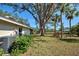 Spacious backyard features a pond, lush greenery, and a home with a screened-in porch at 232 Southampton Ln # 259, Venice, FL 34293