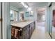 Light and airy bathroom featuring dual sinks, granite countertops, and a mirrored closet at 232 Southampton Ln # 259, Venice, FL 34293