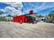 Vibrant red community building offering rentals and services, complemented by palm trees and ample bike parking at 232 Southampton Ln # 259, Venice, FL 34293