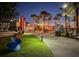 Vibrant community gathering space with lawn, seating, food kiosks, and festive lighting at night at 232 Southampton Ln # 259, Venice, FL 34293