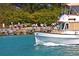 A boat heads towards a dock where people are sitting and relaxing by the water at 232 Southampton Ln # 259, Venice, FL 34293