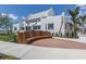 Attractive white building exterior with a wooden bench, brick pavers, and well-maintained landscaping at 232 Southampton Ln # 259, Venice, FL 34293