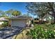 Charming single-Gathering home featuring a manicured lawn, mature trees, and a two-car garage on a sunny day at 232 Southampton Ln # 259, Venice, FL 34293