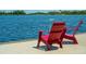 Relaxing lake view featuring comfortable red chairs on a wooden dock, perfect for enjoying the tranquil waterfront at 232 Southampton Ln # 259, Venice, FL 34293