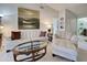 Spacious living room with white leather furniture, a glass coffee table, and a large painting above the sofa at 232 Southampton Ln # 259, Venice, FL 34293