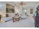 Bright living room showcasing a white sofa, glass coffee table, ceiling fan, and decorative wall art at 232 Southampton Ln # 259, Venice, FL 34293